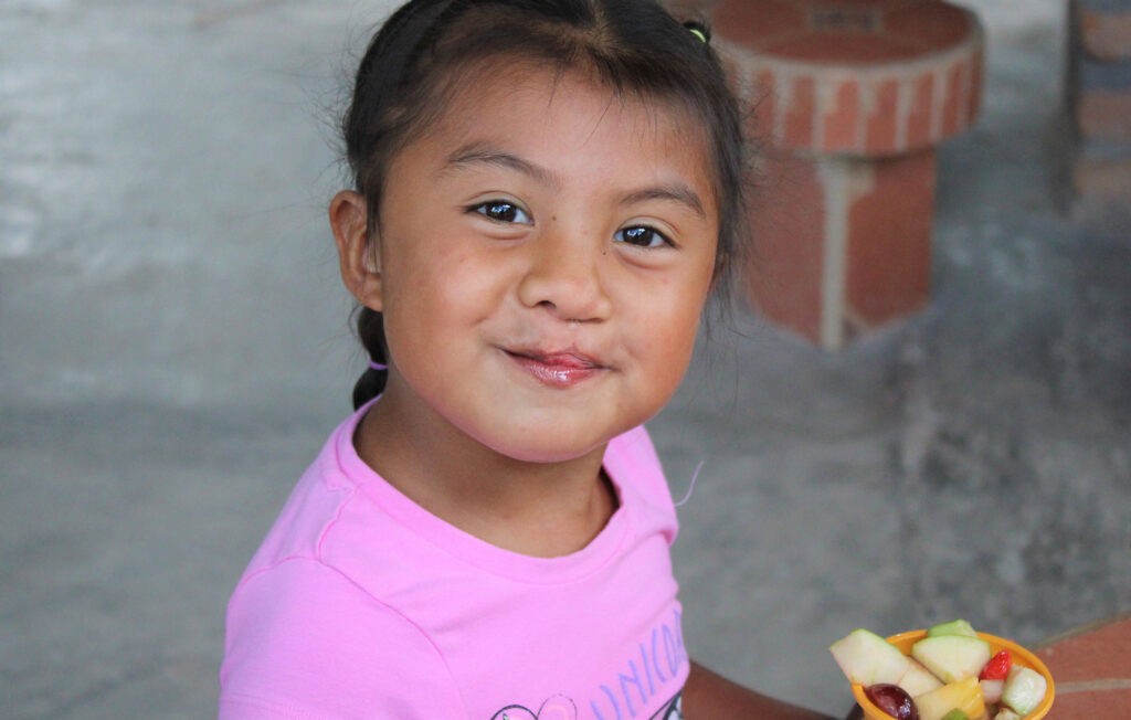 Child at NPH Honduras eating fruit